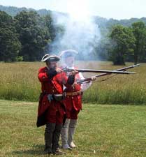 Re-enactors fire colonial rifles at Family Frontier Day at Fort Edwards.